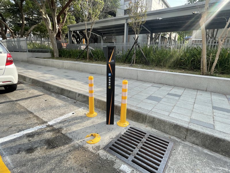 新竹市興學街的智慧停車柱設在路旁，車柱旁還有黃色防撞桿團團「包圍」，但已有防撞桿遭撞「消失」。記者張裕珍／攝影